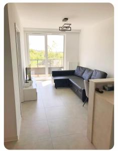 グダニスクにあるApartament Gdańsk 17のソファと大きな窓のあるリビングルーム
