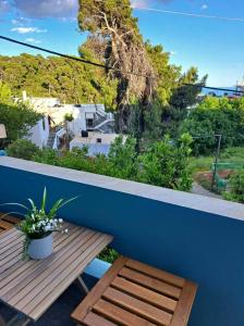 balcón con mesa de madera y pared azul en Orion Studios B, en Centro histórico de Alónnisos