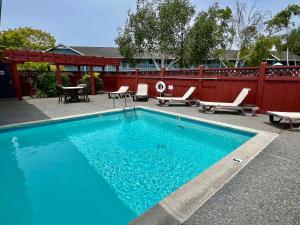 a blue swimming pool with chairs and a table at Best Western Country Inn in Fortuna