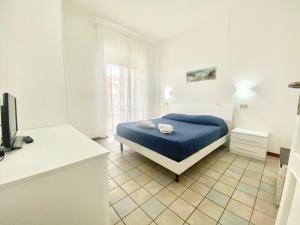 a bedroom with a blue bed in a white room at Il Viaggiatore Serapo in Gaeta