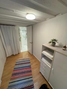 um quarto vazio com um armário e um tapete em Mysig stuga i Nävesta em Örebro