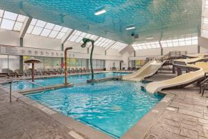a swimming pool with a slide in a building at Best Western Plus Leamington Hotel & Conference Centre in Leamington