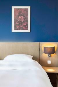 una camera con un letto bianco e una parete blu di Park Inn by Radisson Antwerp City Centre ad Anversa