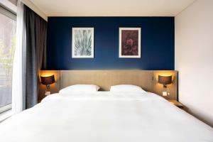 sypialnia z 2 łóżkami i niebieską ścianą w obiekcie Park Inn by Radisson Antwerp City Centre w Antwerpii