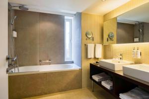 uma casa de banho com uma banheira e um lavatório em Park Inn by Radisson Antwerp City Centre em Antuérpia