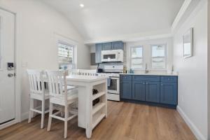 a kitchen with blue cabinets and a table and chairs at Newly Renovated Professional Design Partial Ocean Views in Hampton