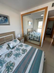 a bedroom with a bed and a large mirror at Ático con vistas al mar y piscina privada in Vera +32 photos