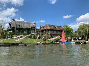 a house on the water with a boat in front of it at Le Duo Porte-Joyeux in Porte-Joie