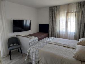 Cette chambre comprend 2 lits et une télévision à écran plat. dans l'établissement Apartments Kolic, à Savar