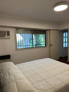 a bedroom with a large bed and two windows at LPR Express in Monte Grande