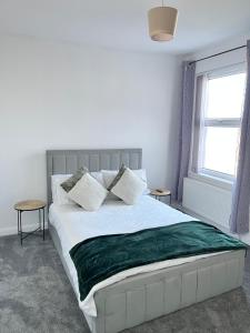 a bedroom with a bed with a green blanket on it at Ty Noah- Home In The Heart Of Pembrokeshire in Milford Haven