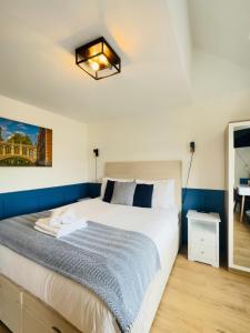 a bedroom with a bed with a blue accent wall at Sun Guest House Cambridge in Cambridge