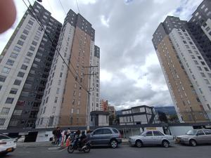 a group of people standing in a parking lot with buildings at Cómodo apartamento central in Pasto