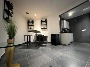 Una sala de estar con una mesa y una cocina. en Suite Julius Cesar, en Berlín