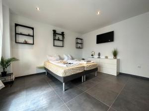Un dormitorio con una cama y un televisor en la pared. en Suite Julius Cesar, en Berlín 8 fotos más