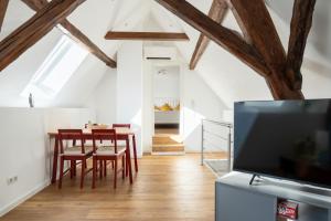 a living room with a dining room table and a tv at Ferienwohnung Loblocher Mühle in Neustadt an der Weinstraße