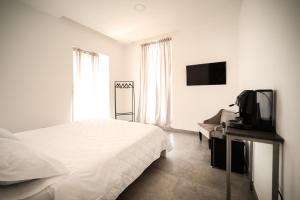 a bedroom with a bed and a tv and a couch at Charme Room&Relax in Torre del Greco