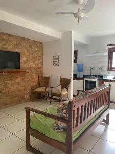 Bahia Bonita Flat في إيتاكاري: غرفة معيشة مع أريكة ومطبخ