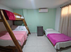 2 stapelbedden in een kamer met roze lakens bij Dreimar Hotel Boutique in Cartagena