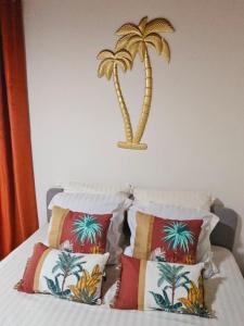 a bedroom with a bed with two palm trees on the wall at Ti Oasis SEAVIEW, Studio Vue Mer à 150m de la plage in Corps de Garde