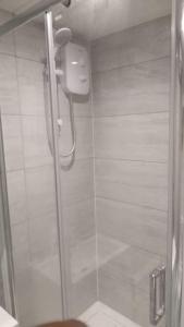a shower with a glass door in a bathroom at Luxurious & Stylish Flat, Access to Public Transport & Shops in Thamesmead