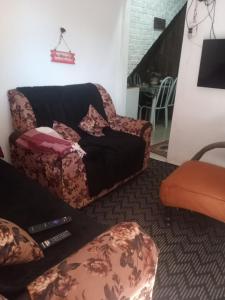 a living room with a couch and a chair at Casinhas no Interior de MG in Antônio Prado