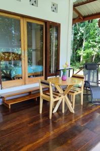 a wooden table and chairs on a porch at VidFauw Oasis Villa 