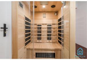 a sauna with wood paneling and a glass door at Belle Room in Gdańsk