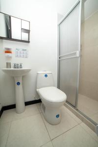 a bathroom with a toilet and a sink and a shower at Apartahotel cerca del Parque del Café, 405A in Montenegro
