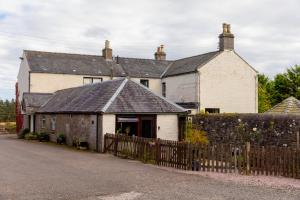 an old house with a fence in front of it at The Bothy in Dundee