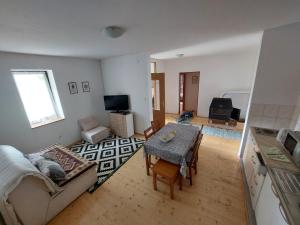 a living room with a couch and a table at Guest house Griva Plitvice in Korenica