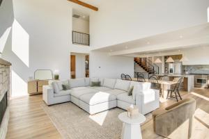 a living room with a white couch and a kitchen at Luxe Retreat with Theater Room Walk to Bear Lake! in Garden City