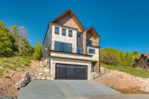a large house with a garage on a hill at Luxe Retreat with Theater Room Walk to Bear Lake! in Garden City