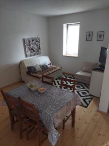a living room with a table and a couch at Guest house Griva Plitvice in Korenica