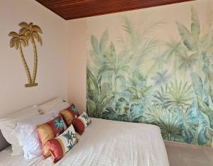 sypialnia z malowidłem palmowym na ścianie w obiekcie Ti Oasis SEAVIEW, Studio Vue Mer à 150m de la plage w mieście Corps de Garde
