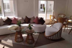 a living room with a white couch and two tables at Casa de playa en exclusivo club, seguridad 24-7 in Salinas +25 photos