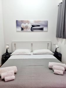 Un dormitorio con una cama con toallas rosas. en La Trinacria Rooms, en Trapani