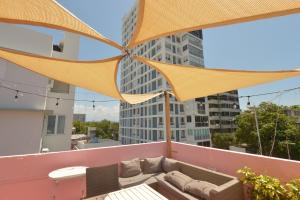 a rooftop patio with a couch and an umbrella at 610@Miramar in San Juan