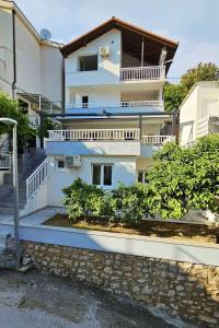 a white building with balconies and trees in front of it at Apartments by the sea Duboka, Neretva Delta - Usce Neretve - 23268 in Klek