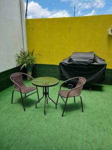 two chairs and a table in a room with a yellow wall at Casa Alamedas Carretera a El Salvador in Pampumay +27 photos