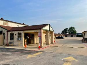 un aparcamiento vacío frente a un edificio en Ankur Inn Motel, en Dallas