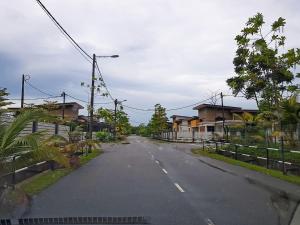 an empty street in a residential neighborhood with houses at Siantan In Paya Rumput Perdana in Melaka