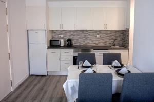 a kitchen with a table with chairs and a refrigerator at Casa Mayte in O Grove