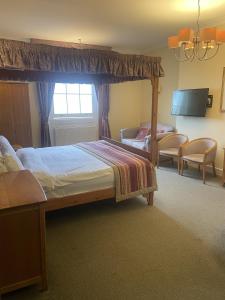um quarto com uma cama de dossel e uma televisão em Hotel 1843 Reading em Reading