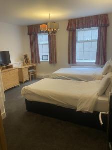 a bedroom with two beds and a flat screen tv at Hotel 1843 Reading in Reading