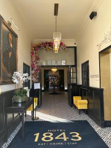a lobby with a waiting area with flowers on the wall at Hotel 1843 Reading in Reading