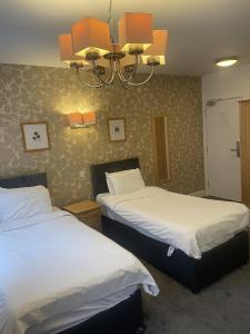 a bedroom with two beds and a chandelier at Hotel 1843 Reading in Reading