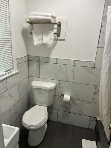 Łazienka z białą toaletą i umywalką w obiekcie Cadet Motel w mieście Cornwall-on-Hudson