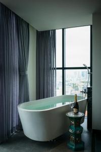 a bath tub in a bathroom with a window at Amanaki Thao Dien in Ho Chi Minh City