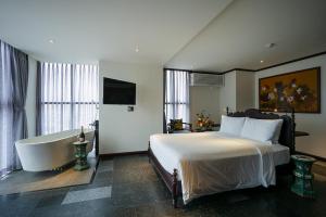 a bedroom with a bed and a bath tub at Amanaki Thao Dien in Ho Chi Minh City